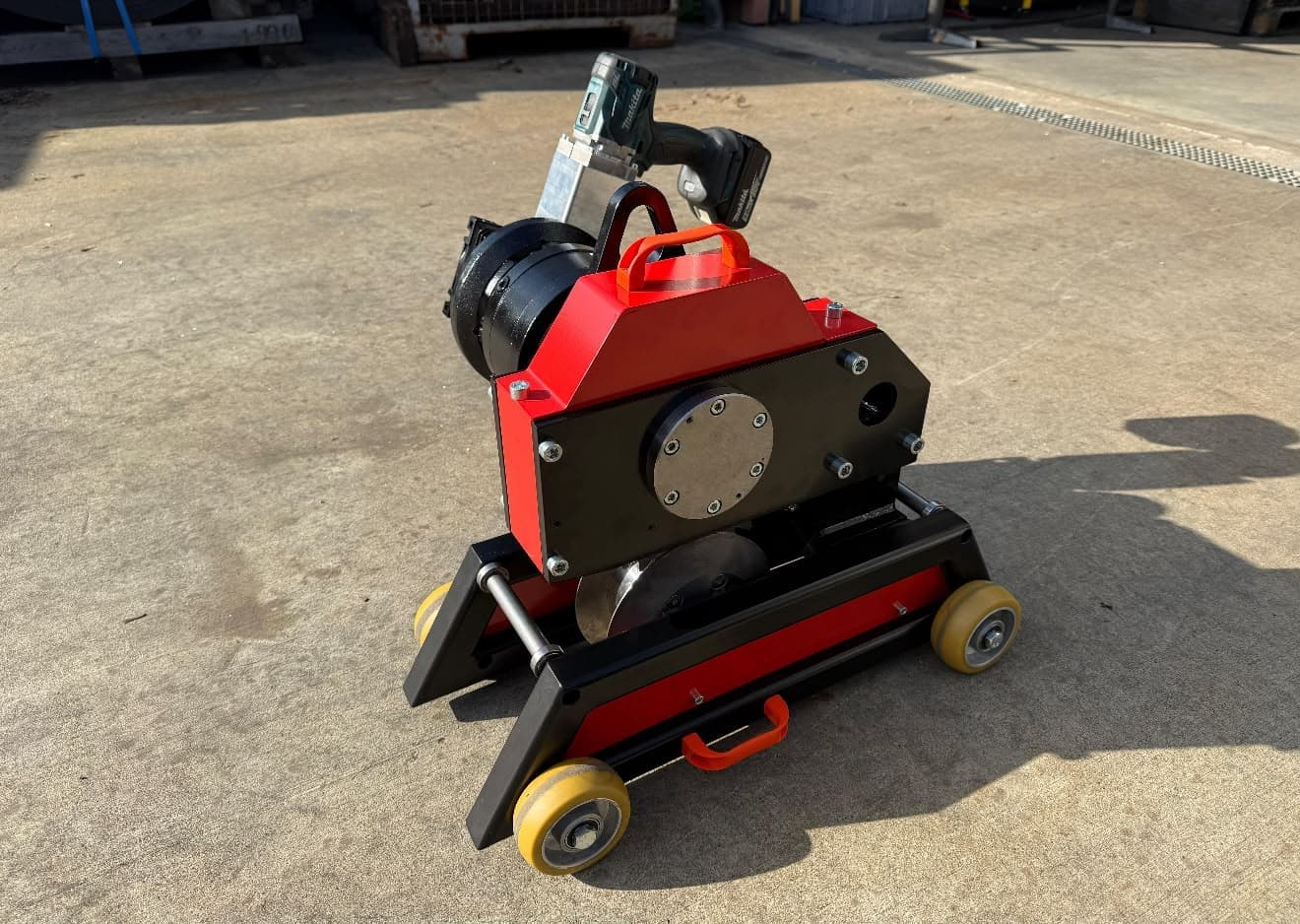 Magnum powered belt cutter on a wheeled trolley with a cordless-drill drive, on a plant yard